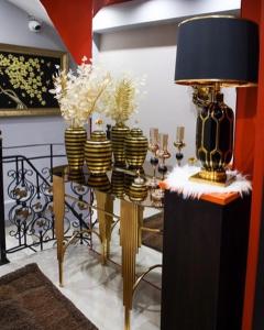 Cette chambre comprend une table avec des vases et une lampe. dans l'établissement Classic House Hotel, à Korçë