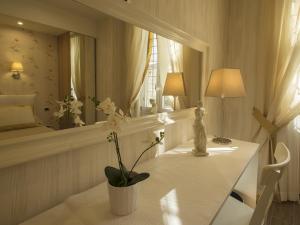 Una habitación blanca con una mesa y un espejo. en Locanda di Mosconi, en Florencia 105 fotos más