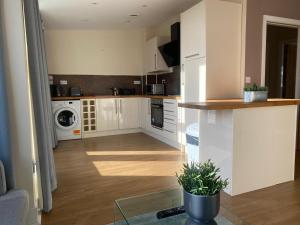 uma cozinha com armários brancos e um balcão em AA Newcastle em Newcastle upon Tyne