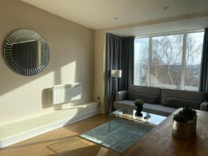 a living room with a couch and a mirror at AA Newcastle in Newcastle upon Tyne