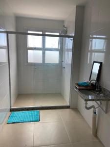 um chuveiro com uma porta de vidro na casa de banho em AP Novo Mobiliado em Salvador