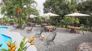 a patio with tables and umbrellas next to a pool at The PAD at Buen Camino Bike Park in San Mateo