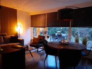 een woonkamer met een tafel en een eetkamer bij Secret Wellness Puur Natuur in Holten