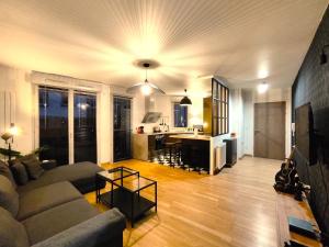 uma sala de estar com um sofá e uma cozinha em TROIS PIECES DE CHARME AUX PORTES DE GENEVE em Annemasse