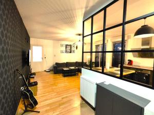 a living room with a couch and a large window at TROIS PIECES DE CHARME AUX PORTES DE GENEVE in Annemasse