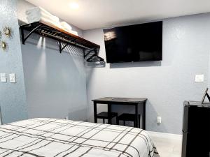 a bedroom with a bed and a tv on the wall at Studio 3! in Lakeland