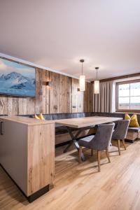 un comedor con una gran mesa de madera y sillas en Appartements Schrambacherhof, en Achenkirch