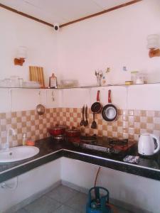 a kitchen with a stove and some pots and pans at Simple Place in Mirissa