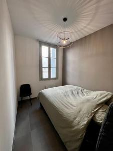 a bedroom with a bed and a window and a ceiling at Le Sainte-Ursule in Montpellier