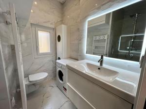 a bathroom with a sink and a washing machine at Le Sainte-Ursule in Montpellier