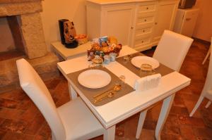 - une table blanche avec des chaises et des assiettes blanches dans l'établissement Terrae Tiferni, à Gioia Sannitica