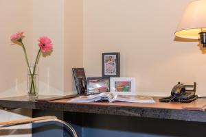 a desk with a vase of flowers and a book at Riviera Suites in Miami Beach