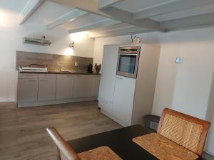 アッペルスカにあるde Gruttoの白いキャビネット、テーブルと椅子付きのキッチンが備わります。