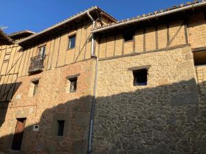 a large brick building with a shadow on the side at El jazmín de la Fuente casa rural in Guijo de Santa Bárbara