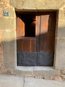 una ventana en una pared de ladrillo con una puerta de madera en El jazmín de la Fuente casa rural en Guijo de Santa Bárbara