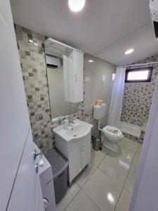 a white bathroom with a sink and a toilet at LIKe A cottage in Perušić +21 photos