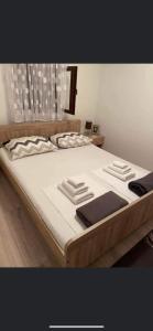 1 cama grande con sábanas blancas y almohadas. en LIKe A cottage en Perušić
