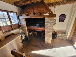 a living room with a stone fireplace in a house at LIKe A cottage in Perušić
