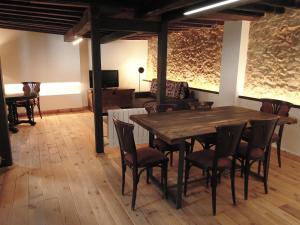 una sala da pranzo con tavolo e sedie in legno di El jazmín de la Fuente casa rural a Guijo de Santa Bárbara