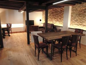 a dining room with a wooden table and chairs at El jazmín de la Fuente casa rural in Guijo de Santa Bárbara