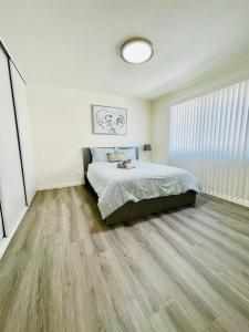 a bedroom with a bed and a wooden floor at Luxury home near Disney land. Entire place! in Orange