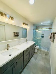 a bathroom with two sinks and a toilet and a shower at Luxury home near Disney land. Entire place! in Orange