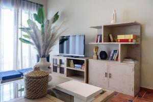 uma sala de estar com televisão e um vaso sobre uma mesa em "SteliosDimitra" House with view in sea of Kantia em Candia