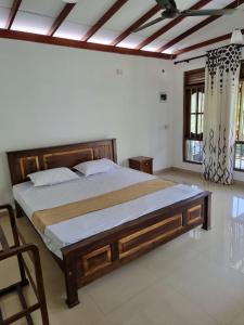 - une chambre avec un grand lit en bois dans l'établissement Green Lodge, à Weligama