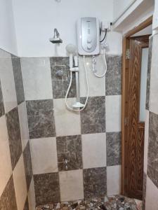 łazienka z prysznicem i podłogą wyłożoną szachownicą w obiekcie Green Lodge w mieście Weligama