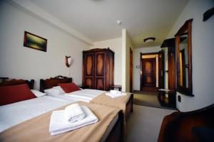 a hotel room with two beds with towels on them at Camelot Club Hotel in Vác