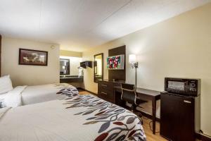 Una habitación de hotel con dos camas y un escritorio con una computadora. en Red Roof Inn Saginaw – Frankenmuth, en Saginaw