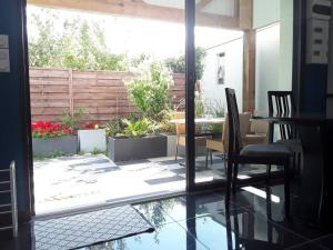 a view of a patio with a table and chairs at Maisonnette 28 M2 au fond du jardin calme&confort in Mondeville