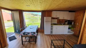 a kitchen with a table and chairs in a cabin at Camping El Roble Verde 