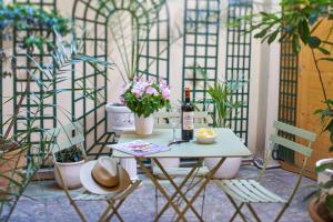 un tavolo con una bottiglia di vino e fiori su un patio di Relais Du Louvre a Parigi