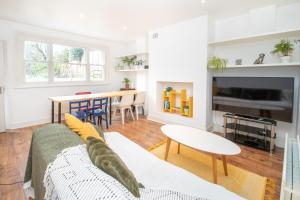 a living room with a couch and a table at Cosy flat in leafy London in London