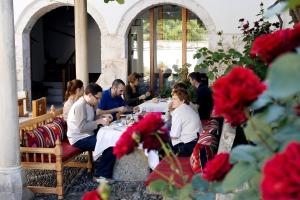 un grupo de personas sentadas en una mesa en un restaurante en Bosnian National Monument Muslibegovic House, en Mostar