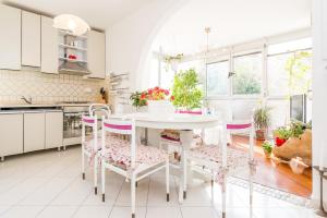 a white kitchen with a white table and chairs at Apartment Rina in Dubrovnik