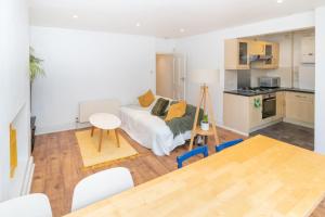 Cosy flat in leafy London في لندن: غرفة معيشة مع سرير وطاولة