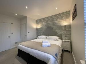 um quarto com uma cama grande e uma parede de tijolos em Isabel Cottage em Keswick
