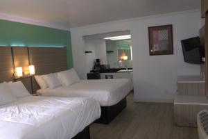 Habitación de hotel con 2 camas y cocina en Discovery Inn, en Hayward