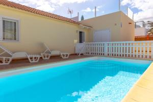 a villa with a swimming pool and a house at Private villa with heated pool & terrace see view in Corralejo