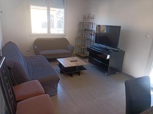 a living room with a couch and a flat screen tv at Appartement Fréjus in Fréjus