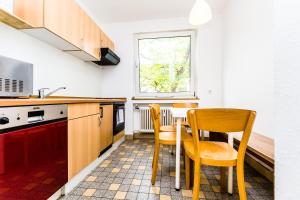 a kitchen with two chairs and a table in it at WelcomeCologne Apartments in Cologne
