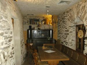 a dining room with a table and a stove at Pension & Apartments Linkemühle in Niederfell