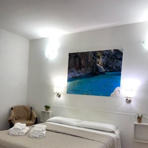 1 dormitorio con 1 cama y una pintura en la pared en Affittacamere Guesthouse Maristella, en Cagliari