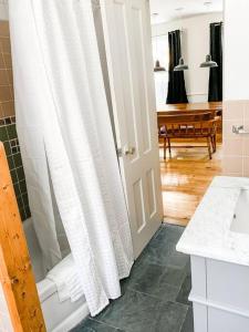 a bathroom with a shower with a white shower curtain at The Brookside Lodge & Cottage in Dover