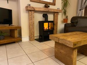 a living room with a fireplace with a stove at Riverbank Cottage Lake District Double Balcony in Egremont