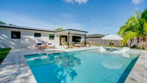 a swimming pool in front of a house at Hidden Oasis in Deerfield Beach with Heated Pool in Deerfield Beach