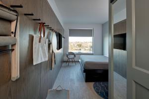 a small bedroom with a bed and a hallway at MOXY Denver Cherry Creek in Denver