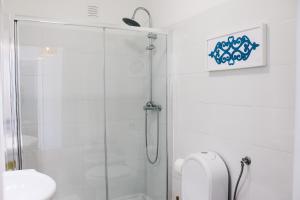 a white bathroom with a shower and a toilet at Amélia - Always Algarve in Armação de Pêra +28 photos